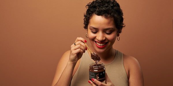 Femme savourant la pâte à tartiner végétale nu3