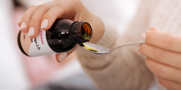 Femme prenant les oméga-3 liquides Redcare