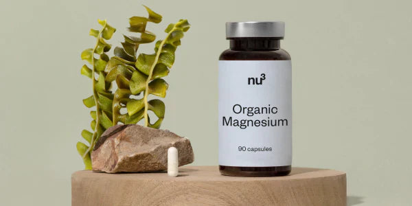 Boîte et gélule de magnésium à côté de la plante de raifort bio
