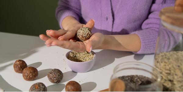 Une femme forme des energy balls avec de la pâte