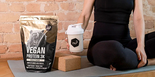 Paquet de Performance whey à côté d'une personne assise un shake à la main