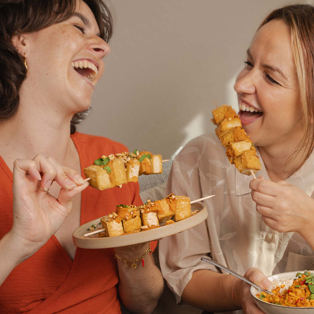 2 femmes mangeant des brochettes de tofu
