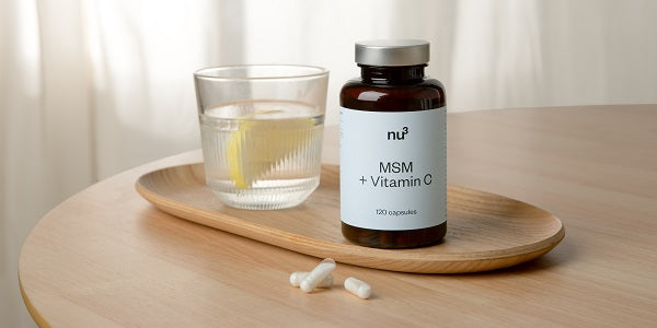 Gélules de MSM nu3 sur une table avec un verre d'eau