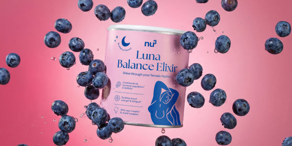 Dose nu3 Luna Balance Elixir vor rosa Hintergrund mit fallenden Blaubeeren